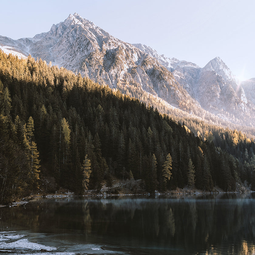 Body of water with forest and mountains behind it
